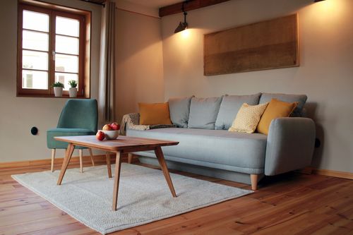 Das Wohnzimmer bietet ein gemütliches Sofa, das zum Schlafen umgebaut werden kann (Liegefläche 160 X 200). (Bild: Fam. Gruber) 