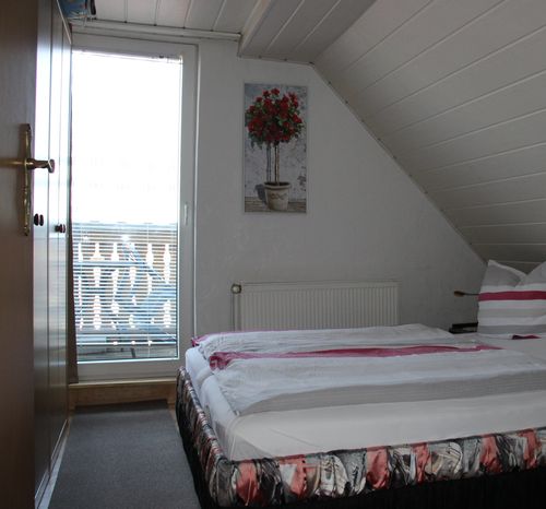 Das zweite Schlafzimmer im Dachgeschoss mit Doppelbett und Balkon mit Schlossblick. (Bild: harztourist)