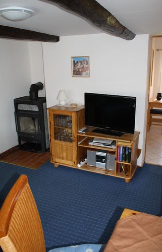 Unsere gemütlichen Wohnzimmer mit Kaminofen, Fernseher und Sitzecke